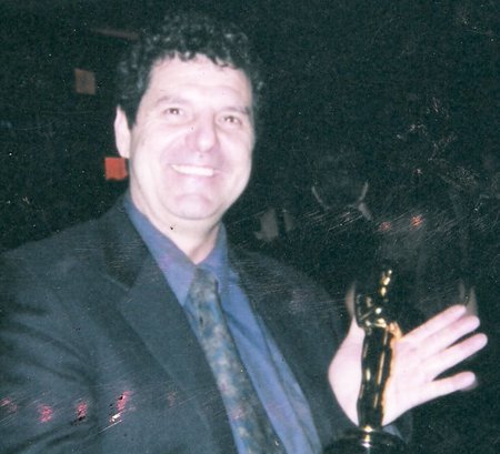 Rich Rossi holds an Oscar at an Academy Awards after party