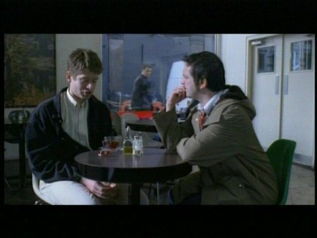 Anthony (James Macartney) meets William (Tom Wontner) at a cafe to discuss 0800Friend.com, whilst Rob (Mem Ferda) looks on through the window.