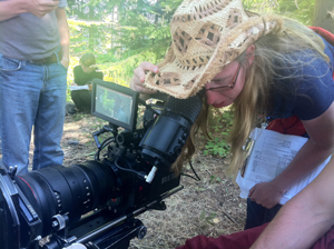 Holly Chadwick as Director checking the frame on the forested set of Seeking Solace.