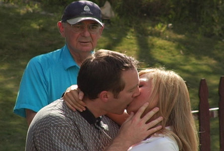 Cindy Pucci and David M. Payne kiss on the driving range as an older golfer stares in amazement during the filming of 