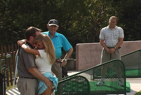 Cindy Pucci and David M. Payne on the driving range as incredulous golfers stare in amazement during the filming of 