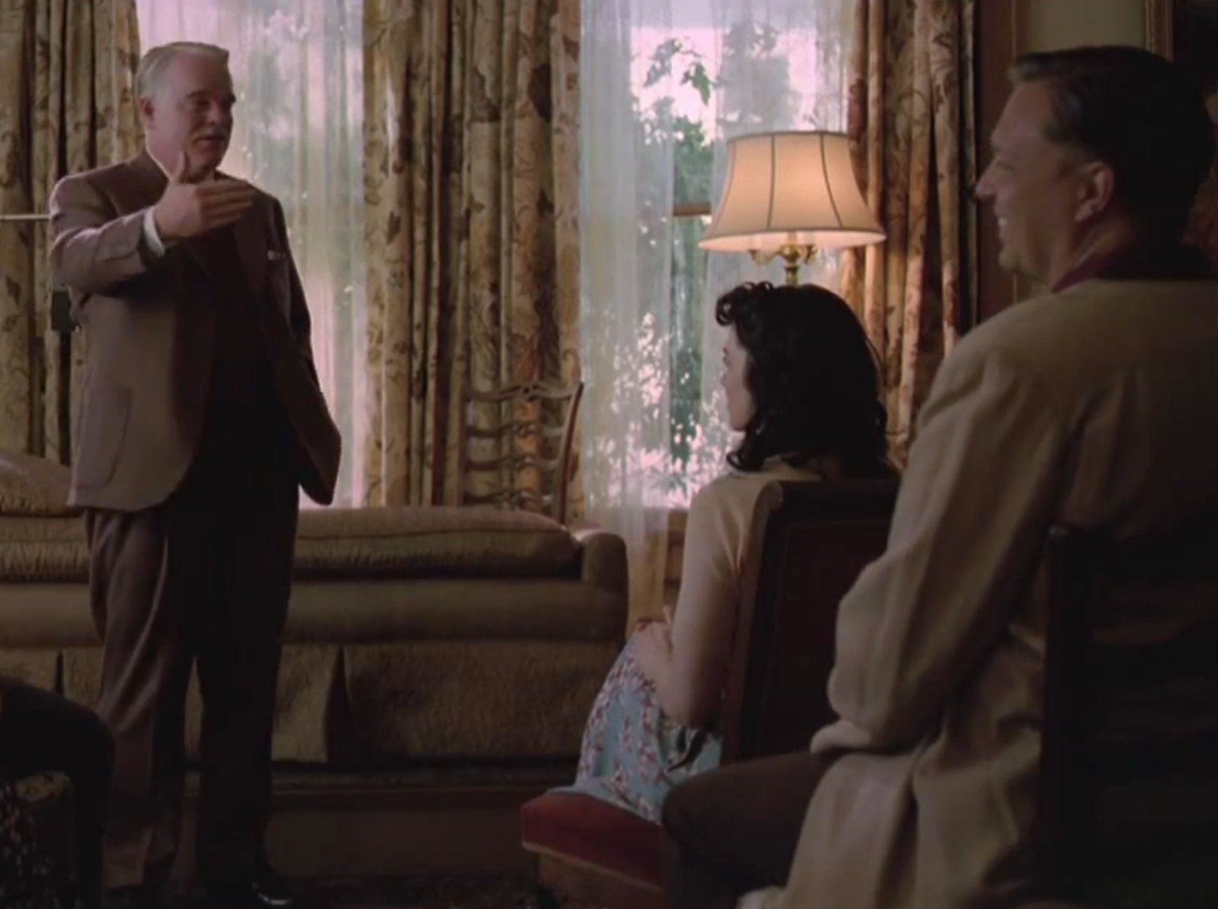 Lancaster Dodd (Philip Seymour Hoffman) speaks to his Philadelphia Followers (Steven Wiig, right) in 