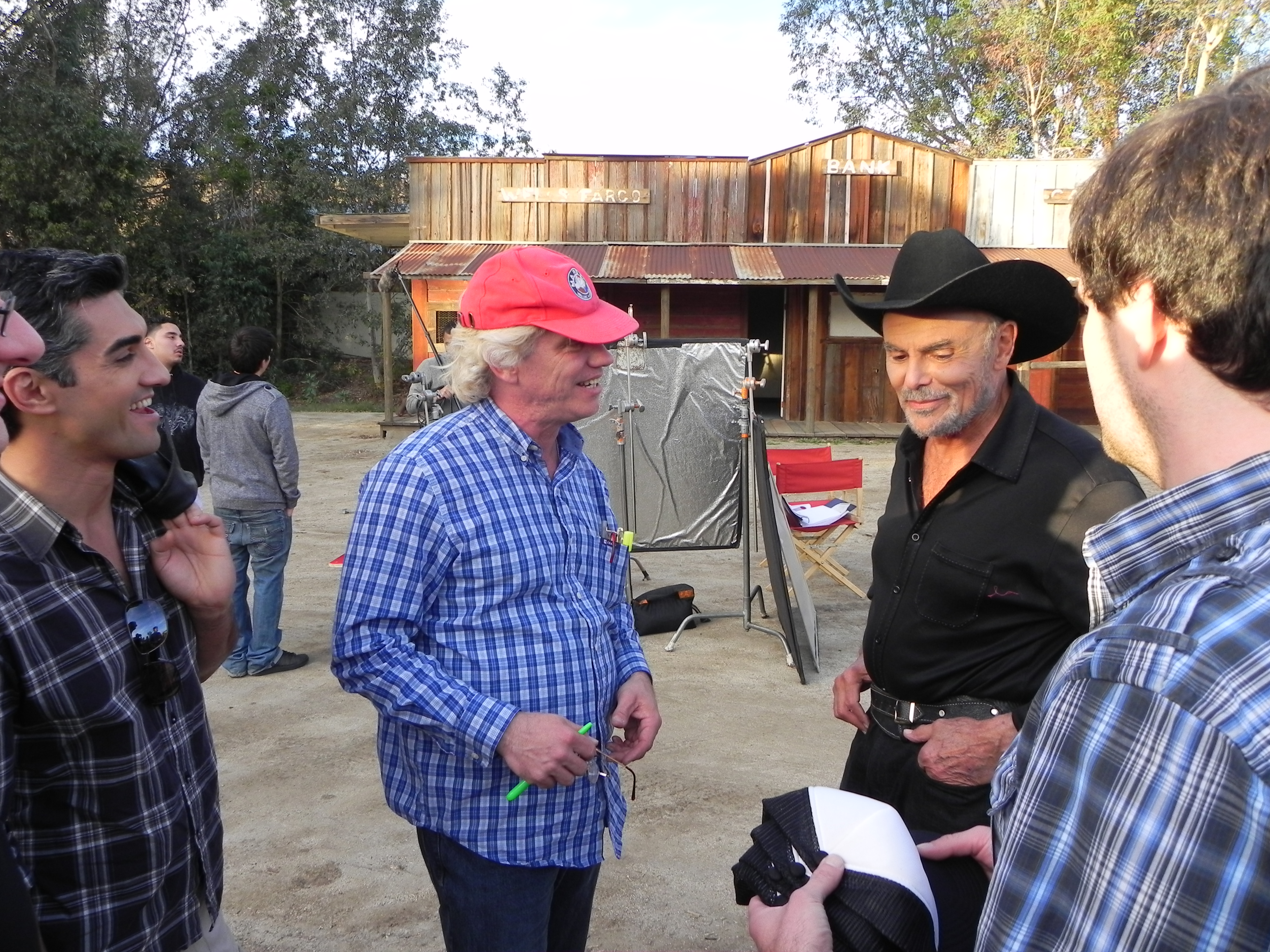 Michael Donahue directs John Saxon on The Extra set at Audie Murphy Ranch. Actor David Imani (L) and production designer Jeremy Lyons (R) discuss western sequence.