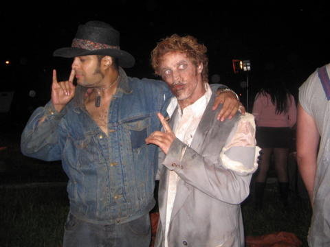 ZOMBIE NIGHT 2 (2006)-Behind-The-Screams Horror Movie Cast/Crew pix Actor: Tony 'Tex' Watt shown here onset w/ actor & lead zombie: Brendan Mertens [R], from personal collection of cast and crew of PrimalFilms.com's ZOMBIE NIGHT 2 [aka AWAKENINGS]; Watt filmed FRANKENPIMP & VIXEN HIGHWAY 2006: IT CAME FROM URANUS , between acting in this movie and Primal Film's REEL ZOMBIES. Copyright 2005, Tony Watt All Rights Reserved