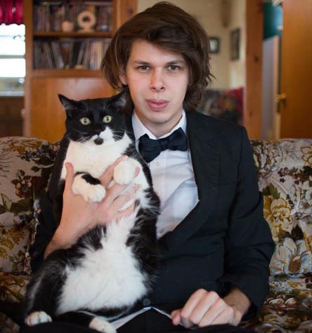 Matty Cardarople in a Tuxedo with his tuxedo cat Hunter.