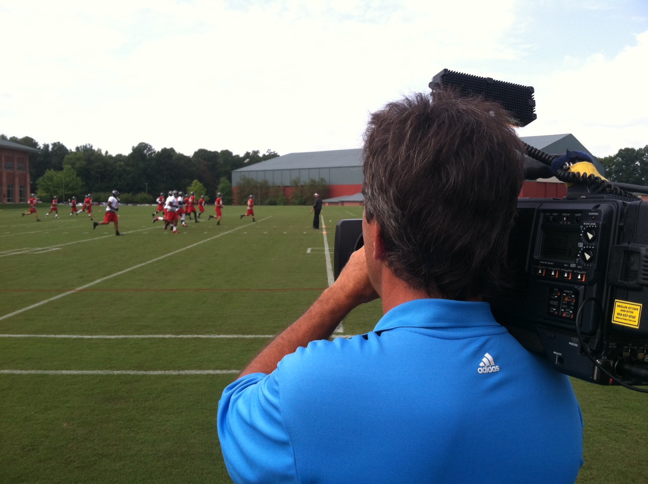 Troy shooting an NFL football practice.