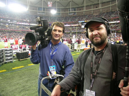 Inertia Films' cameraman A. Troy Thomas (L) and soundman Darryl Mitchell (R) shoot for NFL Network at a Carolina Panthers v. Atlanta Falcons game in Atlanta's Georgia Dome.