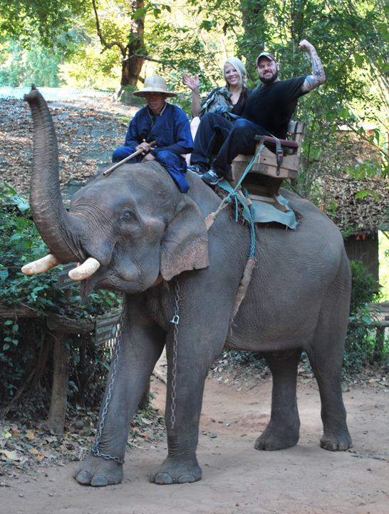 Lin Zy and Matt Busch atop an elephant riding through the jungles of Chaing Mai, Thailand while scouting locations for Aladdin 3477.
