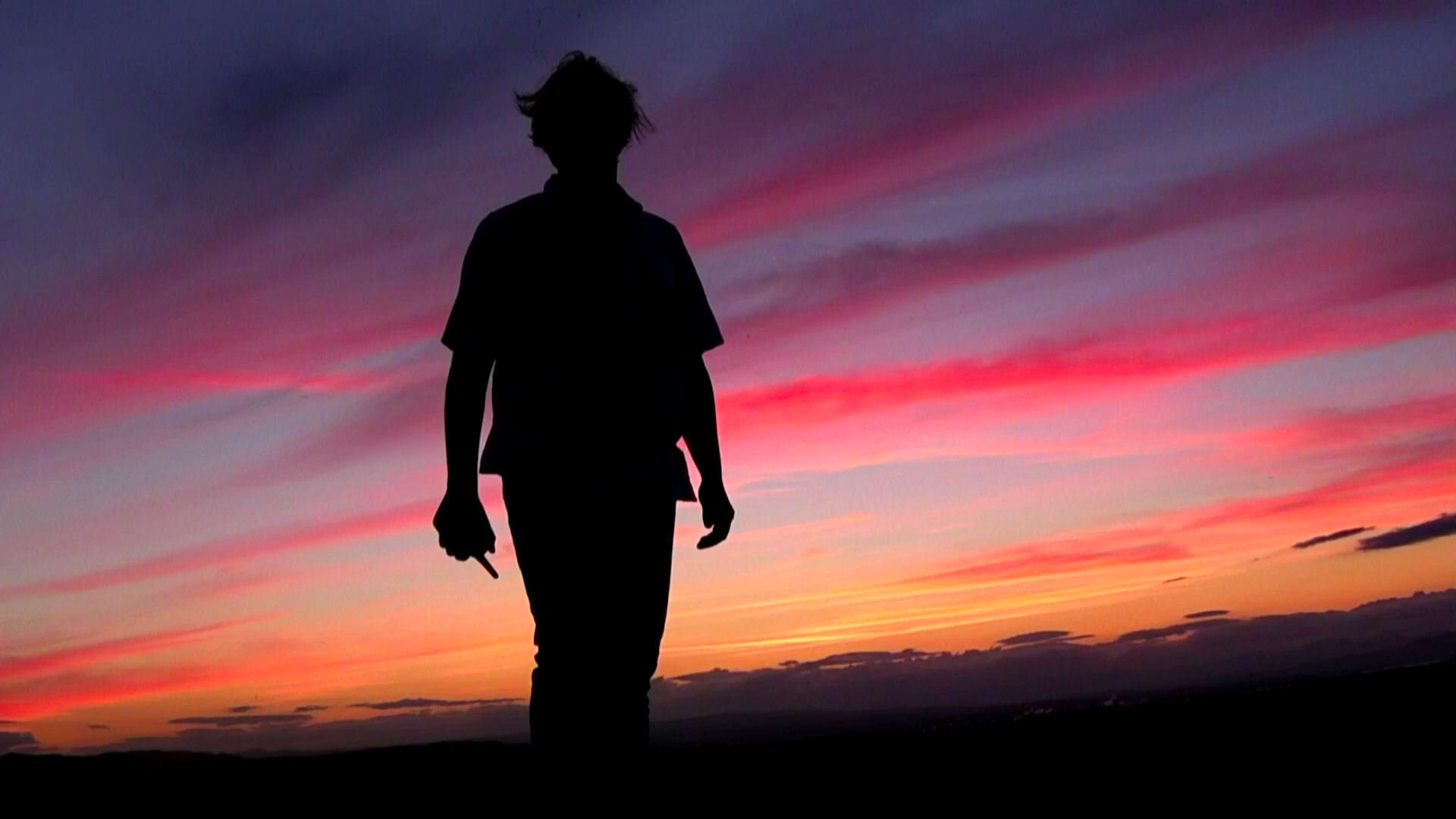 Shawn stands before the morning sky.