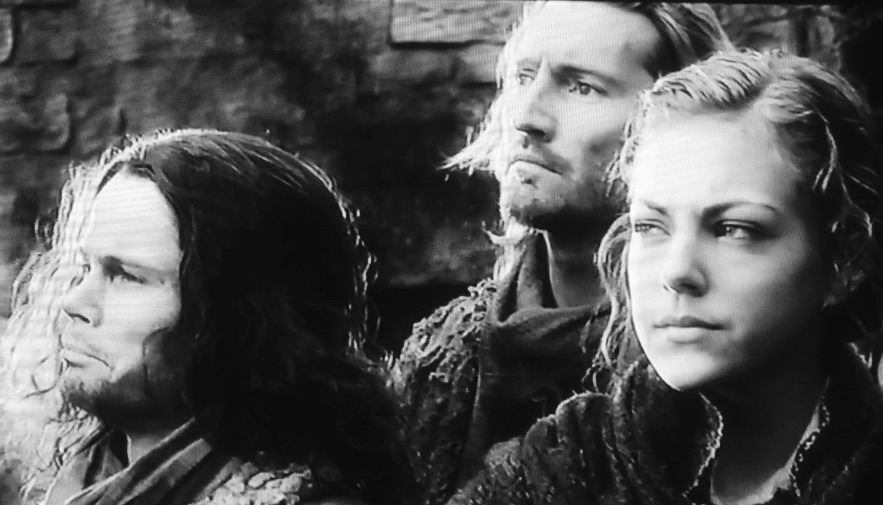Hobbit, Battle of the Five Armies, left to right credit, somber villagers, Jamie Haugh, Michael M. Foster, and Bard's eldest daughter Sigrid, Peggy Nesbitt