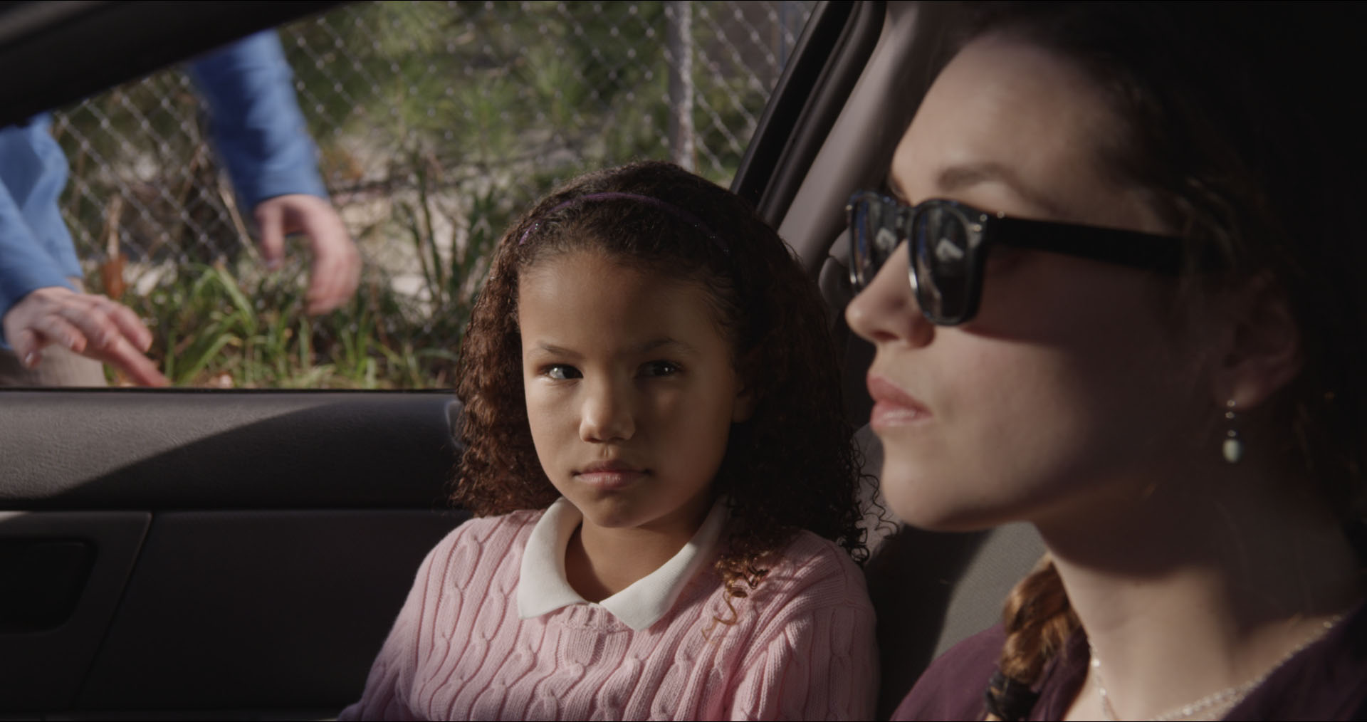 Tia (played by Alessandra Shelby Farmer) gets a ride to school from her new stepsister Carrie (played by Kerry Knuppe) in independent thriller HOME.