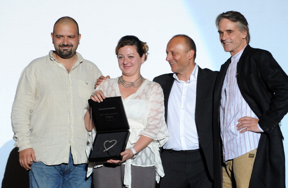 Filmmaker Diana El Jeiroudi receives with her partner Orwa Nyrabia the Katrin Cartlidge Award at Sarajevo Film Festival 2012 presented by Festival director Mirsad 'Miro' Purivatra and Jeremy Irons.