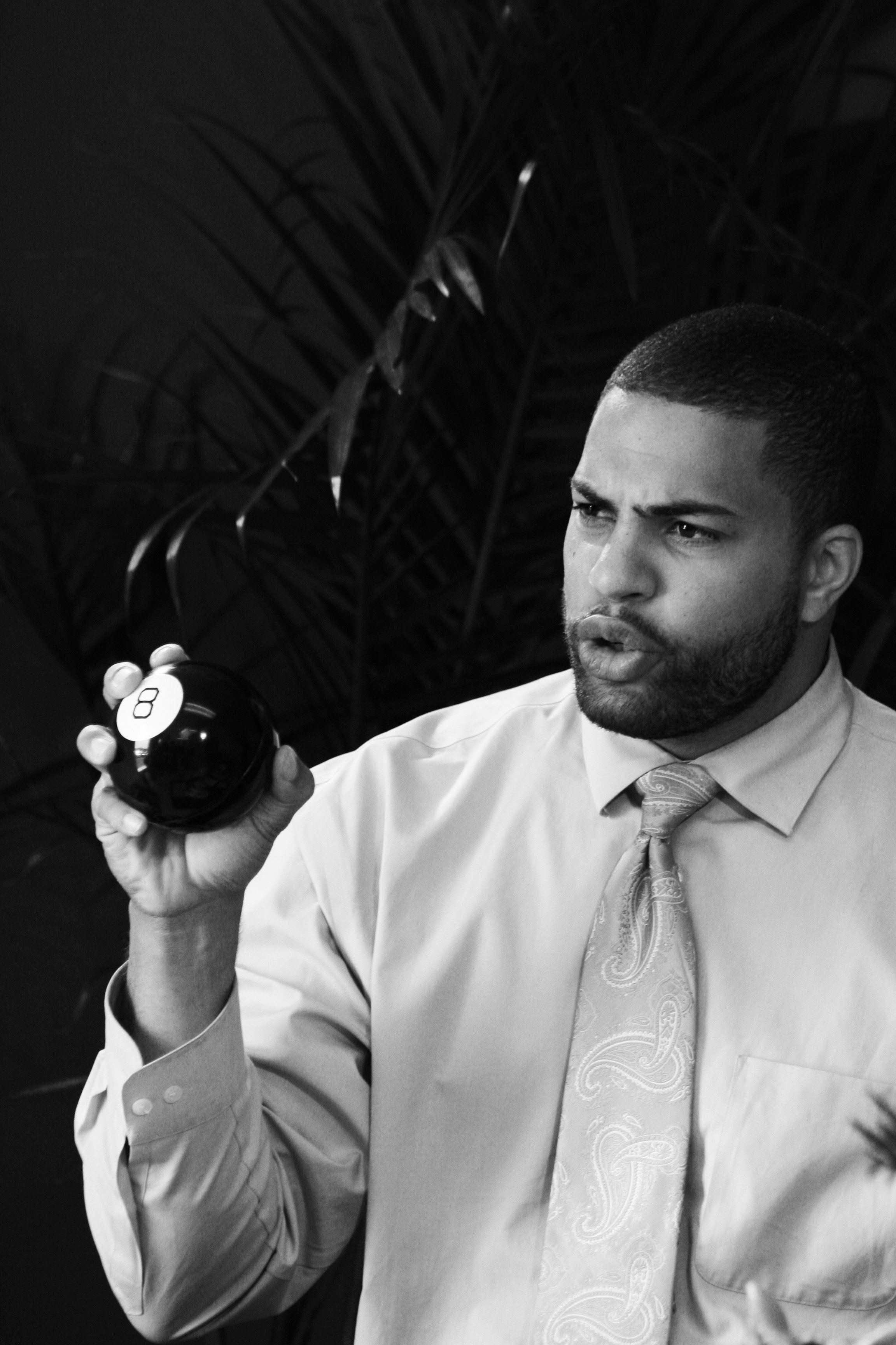 Actor/producer Neil Green playing the role of used car salesmen Brice, holding up the much coveted Magic 8 Ball