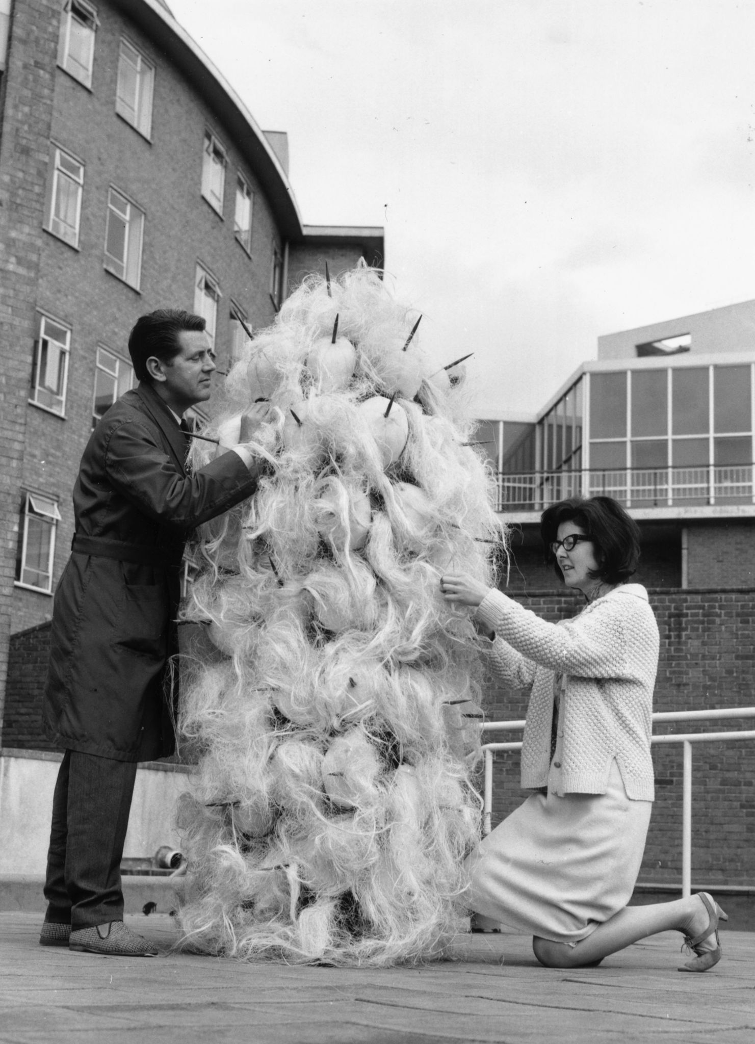5th August 1965: Daphne Dare, who designs all the Dr Who costumes, with her latest creation, a Varga. Assisting is John Athins of the BBC wardrobe Dept.