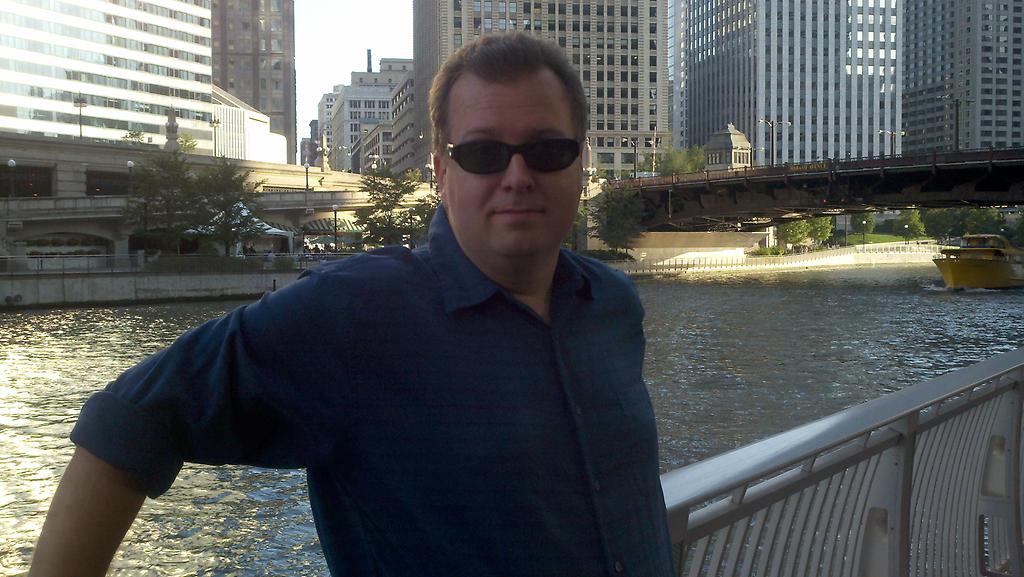Matthew Allen standing along the Riverwalk near Trump Tower in Chicago, IL