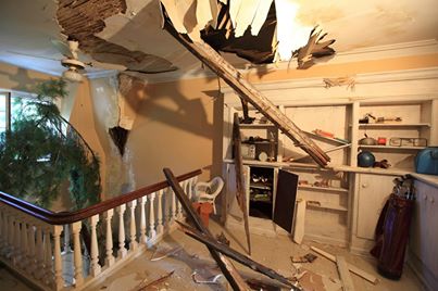 Fake damage to interior of location home for German TV movie. Wall unit also part of fabrication (covers 2 doors to rooms behind). Tree branches also part of set dressing.