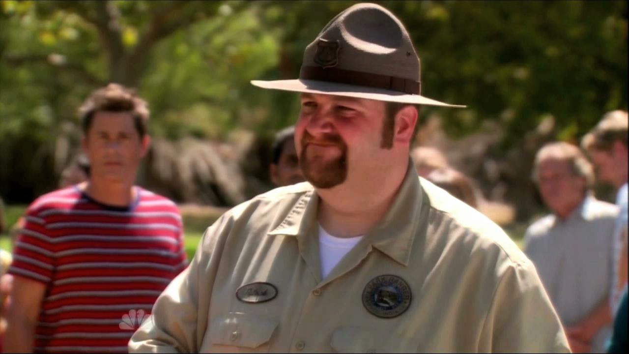 Chris Traeger (Rob Lowe) looks on as Ranger Patrick (Ben Zelevansky) rejects Ron Swanson's permit to slaughter a pig on 
