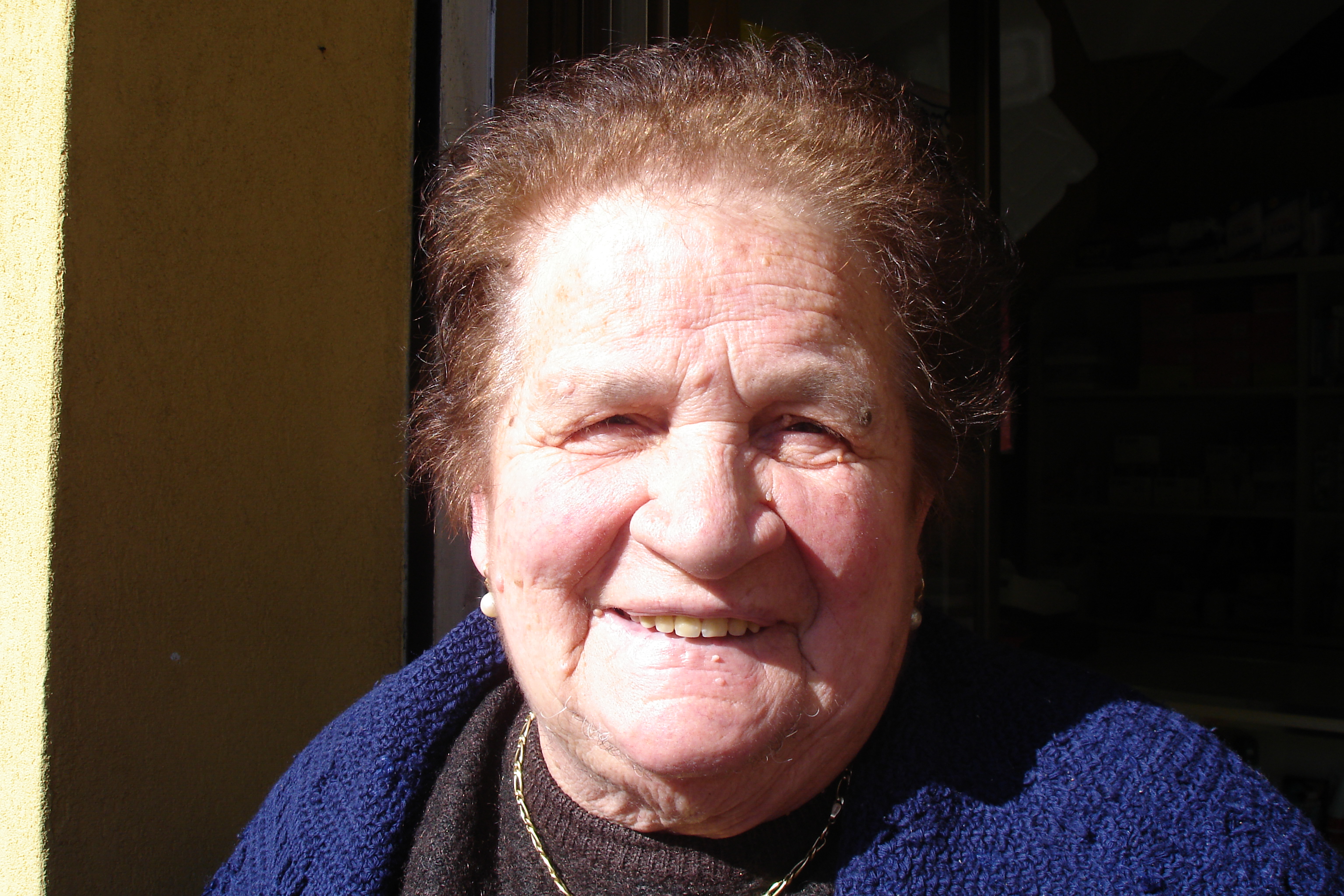 A Sicilian woman in Piana degli Albanesi, Sicily smiling for A SICILIAN ODYSSEY crew on location