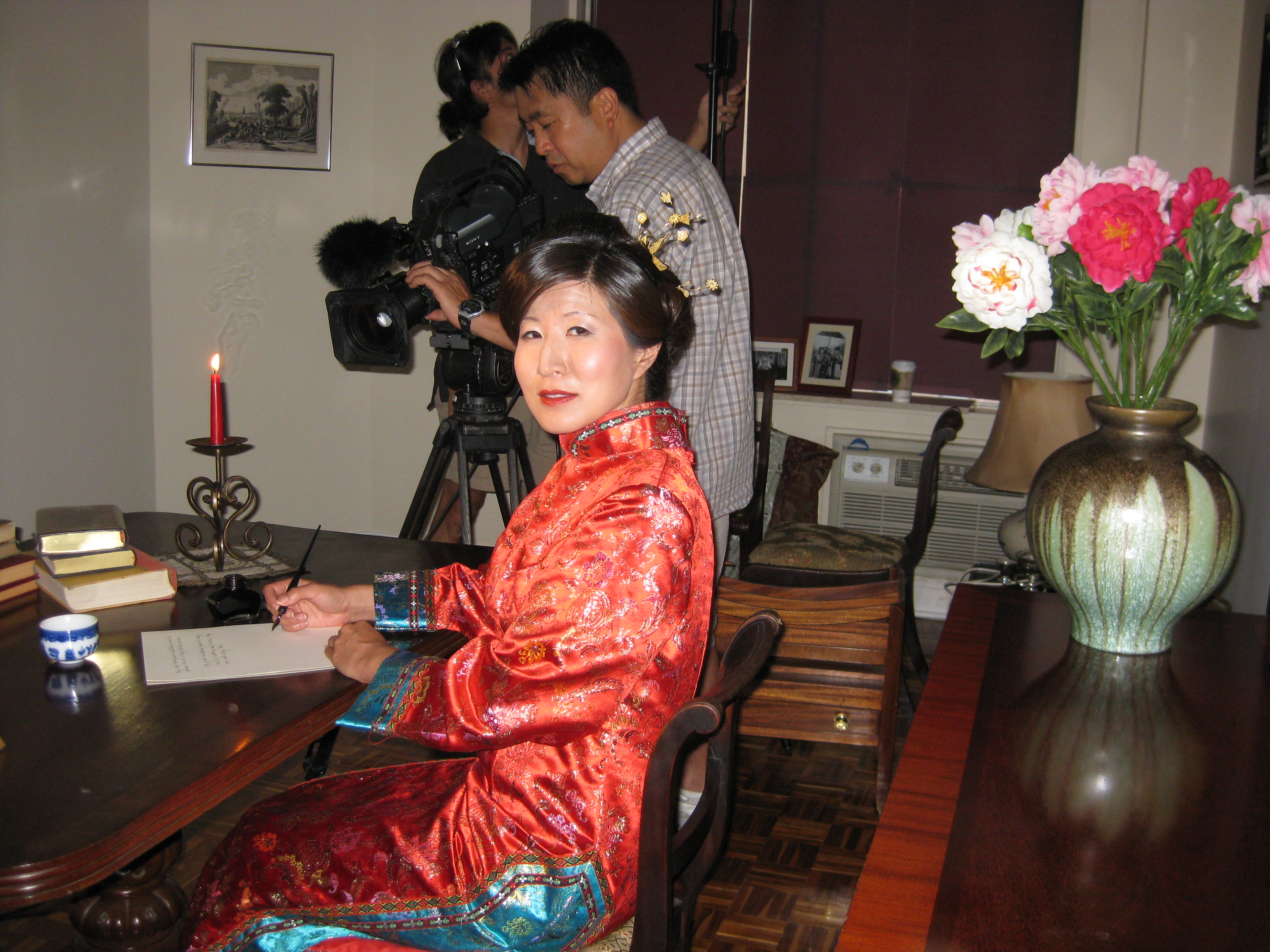 Lil Rhee as Princess Der Ling, sitting at the desk