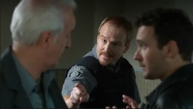 Michael Coady as Reg, The Penitentiary Sign-in Guard (with Sean McGinley and Allan Hawco