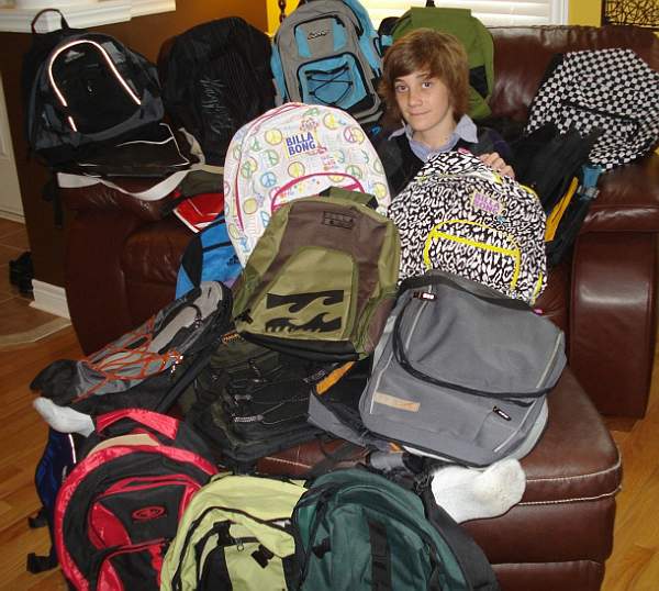 Austin with backpacks he collected ffor Blessings in a backpack charity!!!