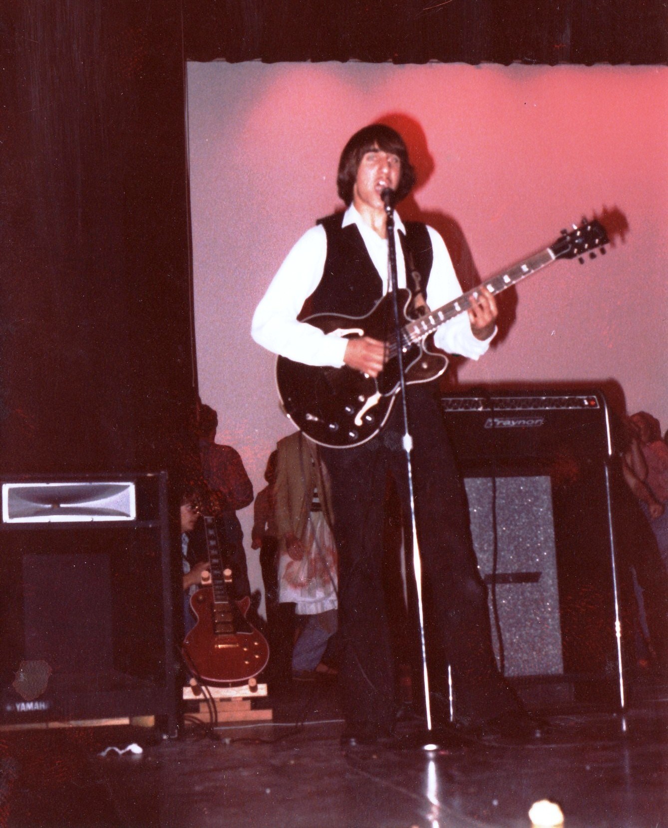 Alex performing live as a background singer and lead guitarist for the band 