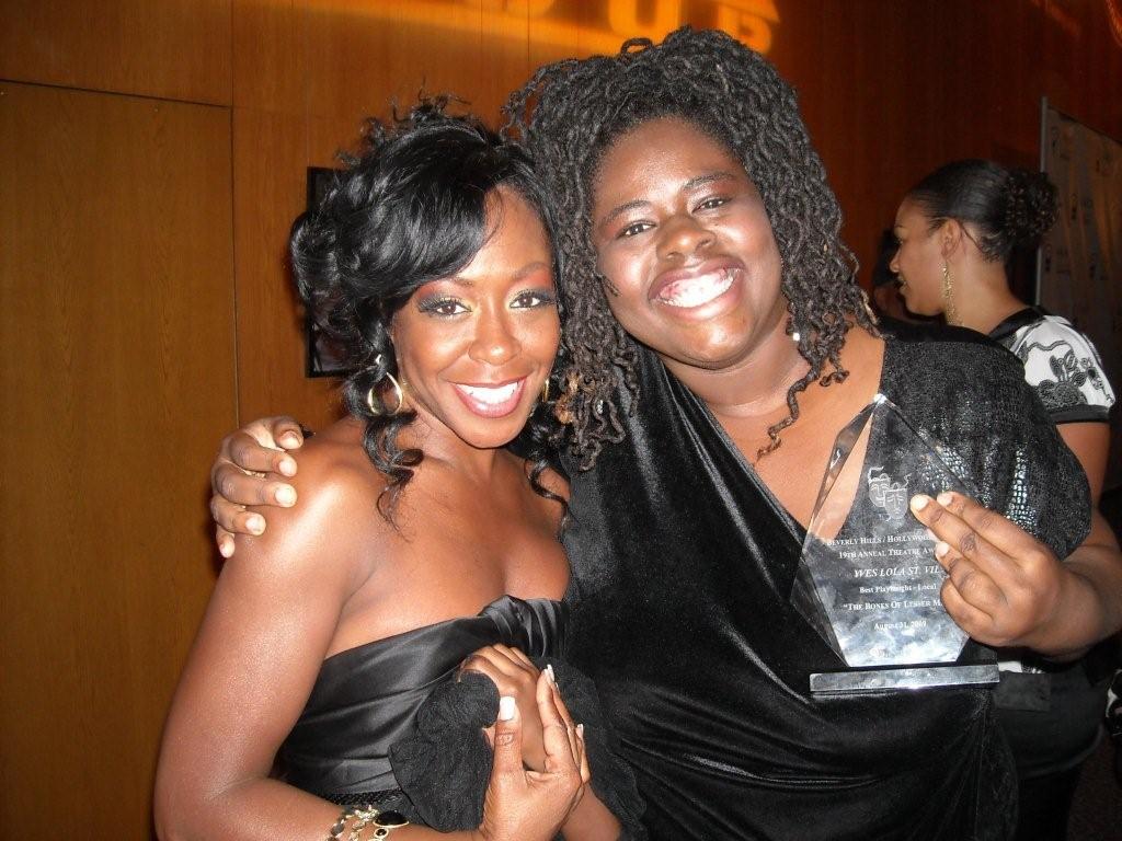 Yves Lola winning the NAACP award for best playwright. Featured in photo is Actress Tichina Arnold.