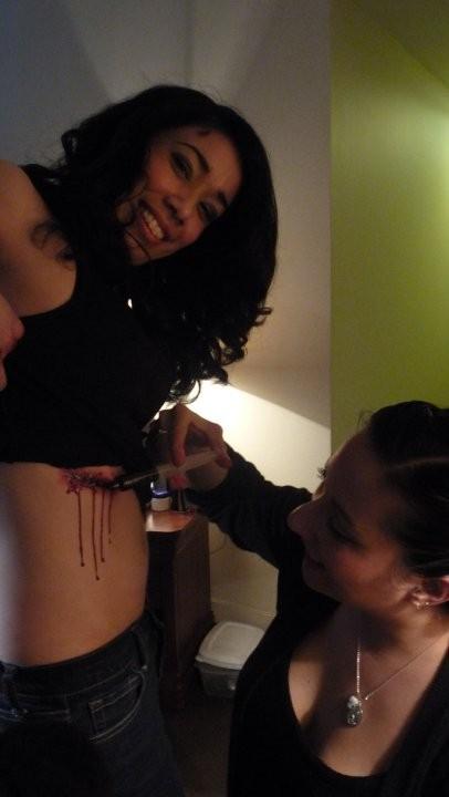 Picture of Special FX Makeup artist Ruby Muro adding fake blood to wound before scene.