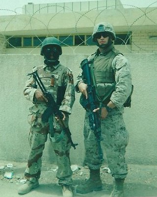 Andrew in Iraq 2005 while serving his country as a United States Marine. Next to him is an Iraqi Soldier he was training.