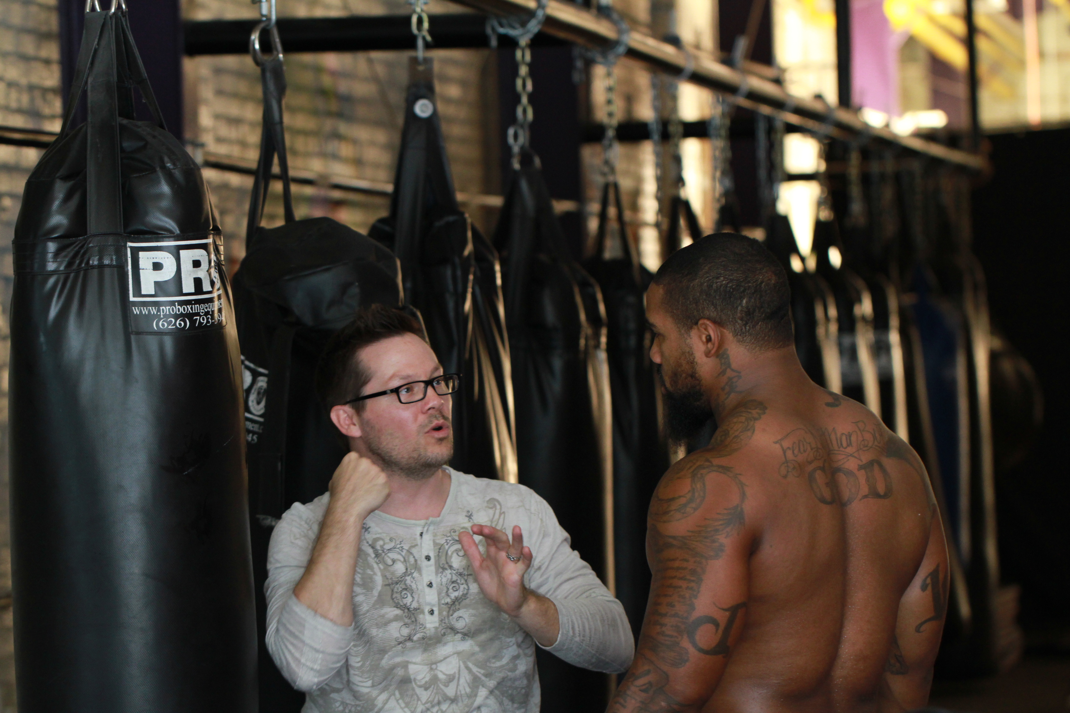 Nate Adams directs fighter James Wilson on the set of 