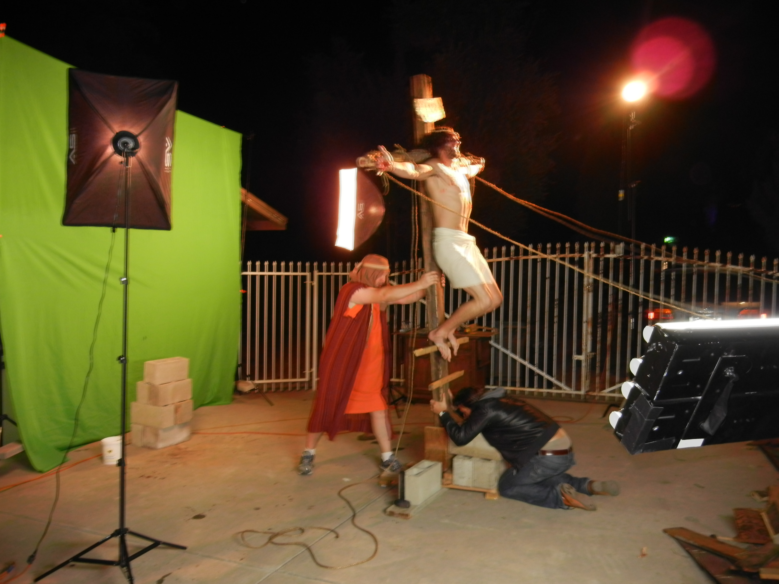 Andrew Skully portraying Jesus while being lifted up on the cross as Brian Reed Garvin and Brian Iliescu hold him for safety in this green screen effects scene.