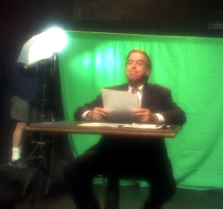 As a newsman using 'green screen'.