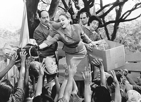 Adored by the people of Argentina, Eva Peron (Madonna, center) uses her position as First Lady to help the masses.