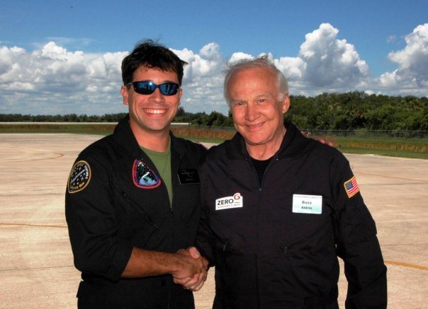 Matthew F. Reyes greets astronaut Buzz Aldrin after flying aboard the ZERO-G aircraft