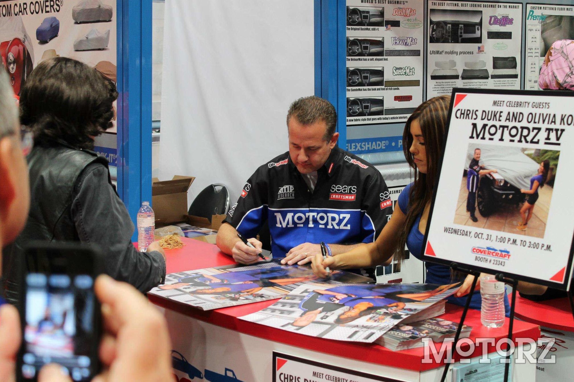 Chris Duke signing posters at the 2012 SEMA Show (Las Vegas Convention Center, Covercraft Booth)
