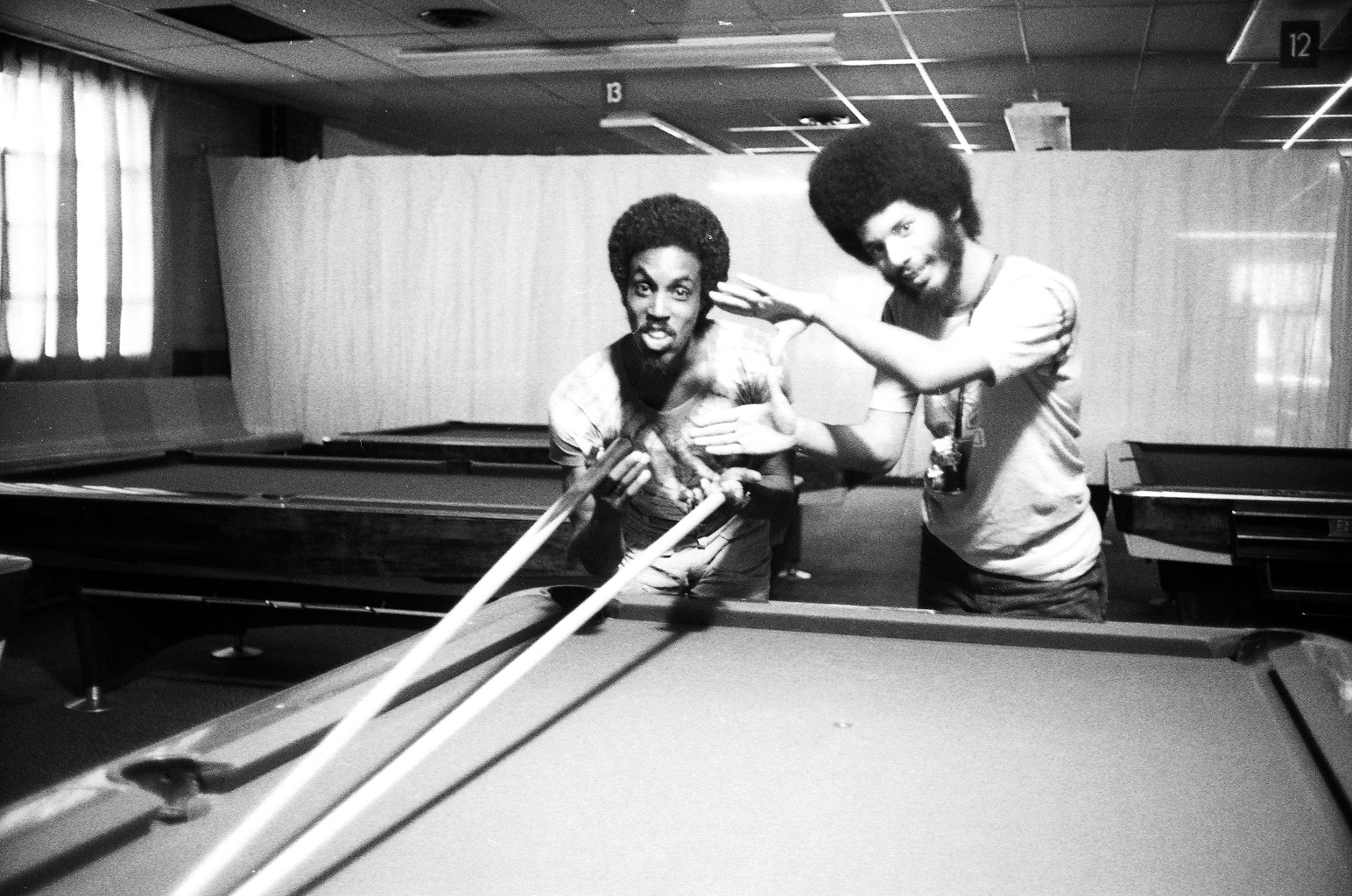 Cinematographer Adrian Best takes a shot at the pool table with assistant cameraman Ronald Gray during the filming of POOL HALL GIRL.