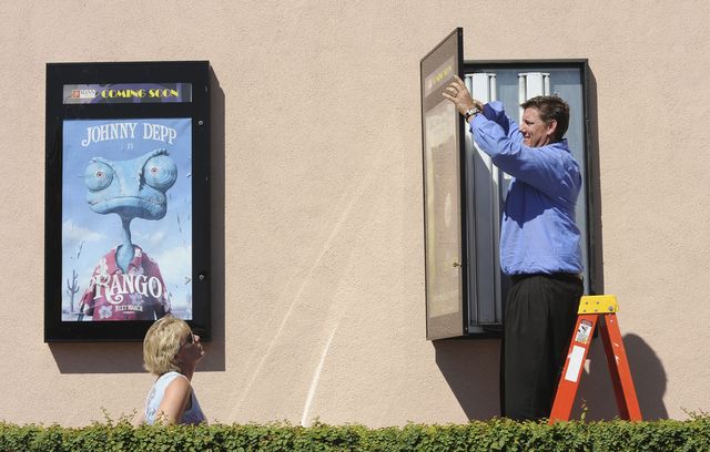 Above, Melanie Morrow and her husband, Christopher, hang posters for Like Dandelion Dust, which will be screened and submitted for consideration during the coming Hollywood awards season.