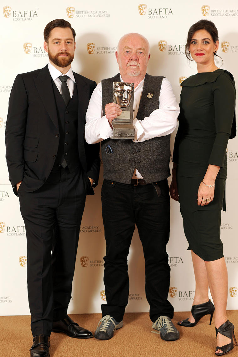 Richard Rankin and Neve McIntosh presenting the 2015 BAFTA Scotland award for Best Director to Donald Coutts for Katie Morag.