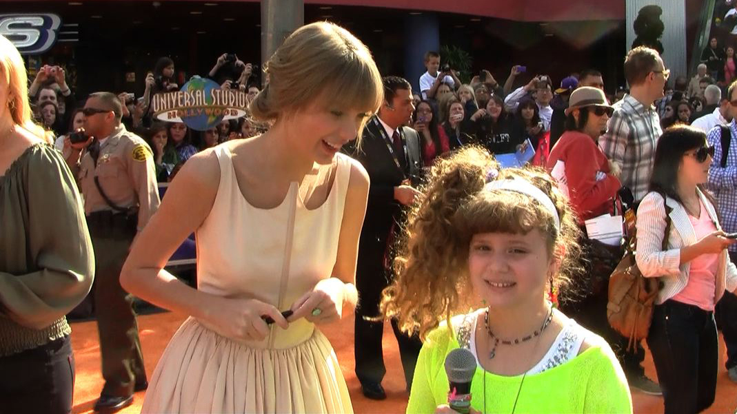 Piper Reese interviewing Taylor Swift on the orange carpet for 