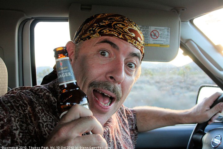 Drinking and driving on a remote dirt road near Area 51 in Nevada. (Glenn actually drinks very rarely. It would take him hours to drink a bottle this size.)