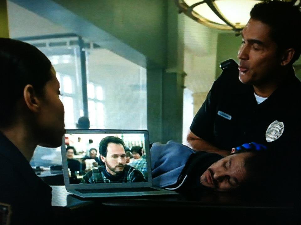 Sill from Xfinity Streampix commercial in which a criminal (portrayed by Karl Maschek) is mesmerized by Streaming video at the Police Station.