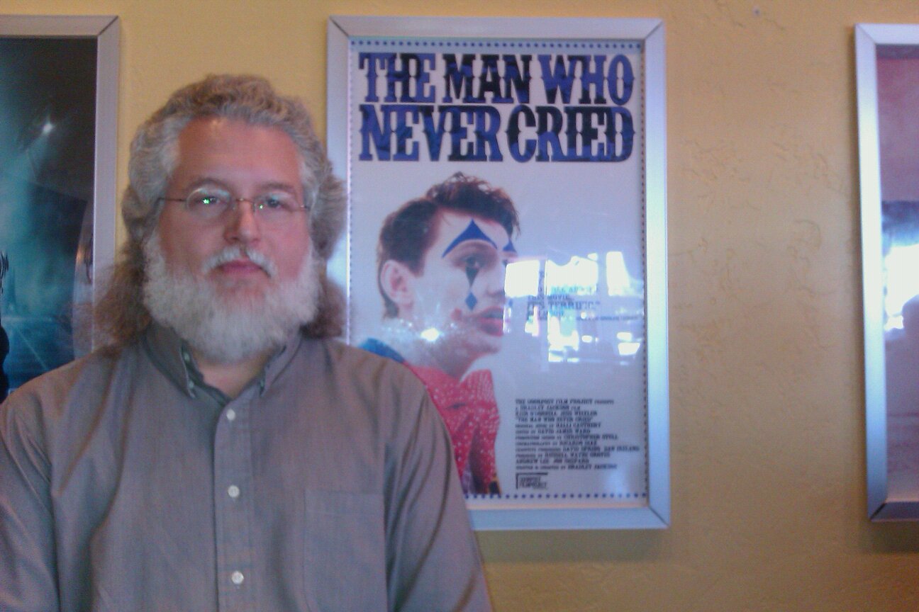 Mark Connelly Wilson standing next to the poster for the award winning short film 