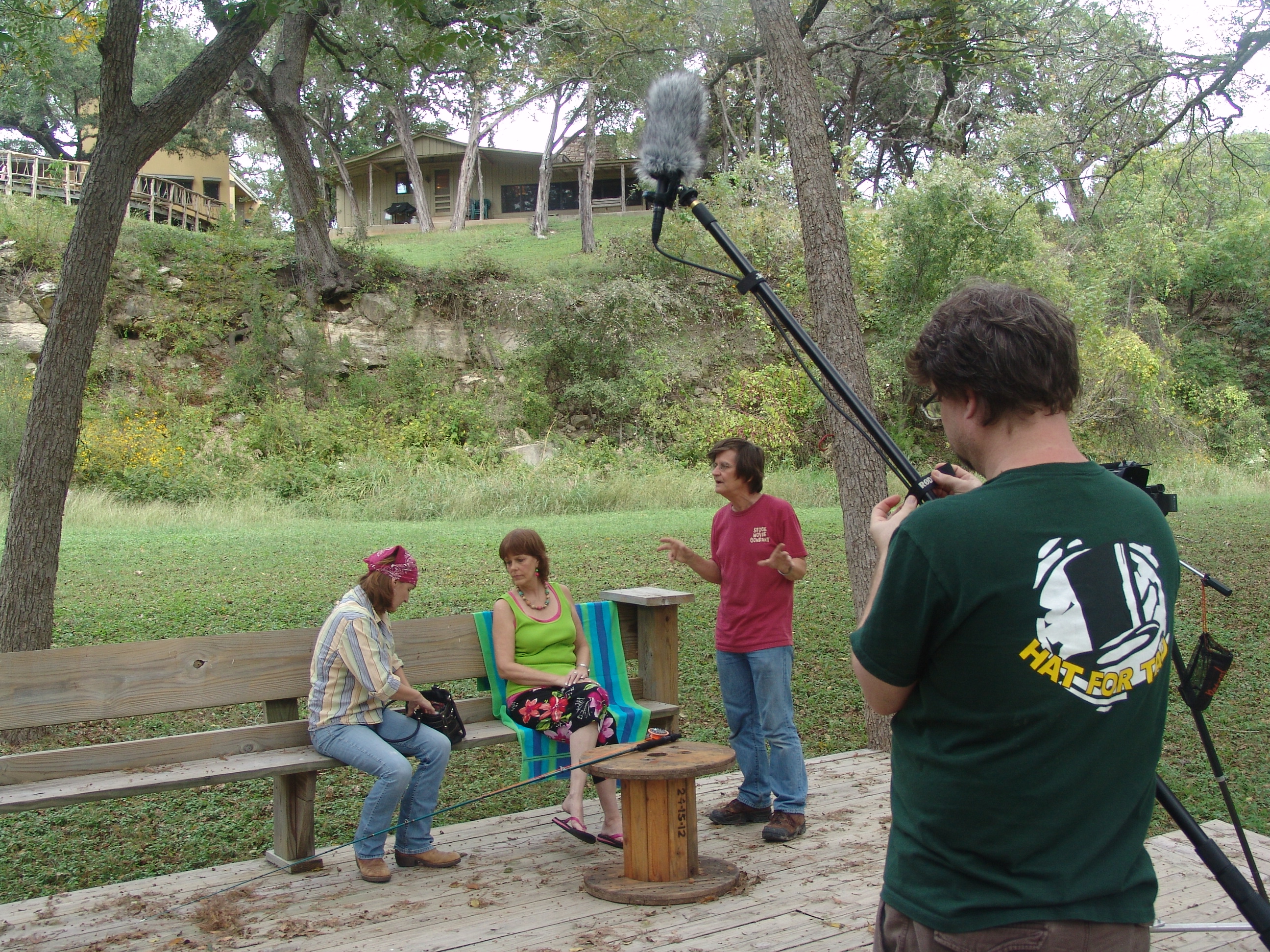 Melinda Ellisor, Gina McClure and Rodger Marion discuss a scene. Morgan Marion adjusts the microphone.