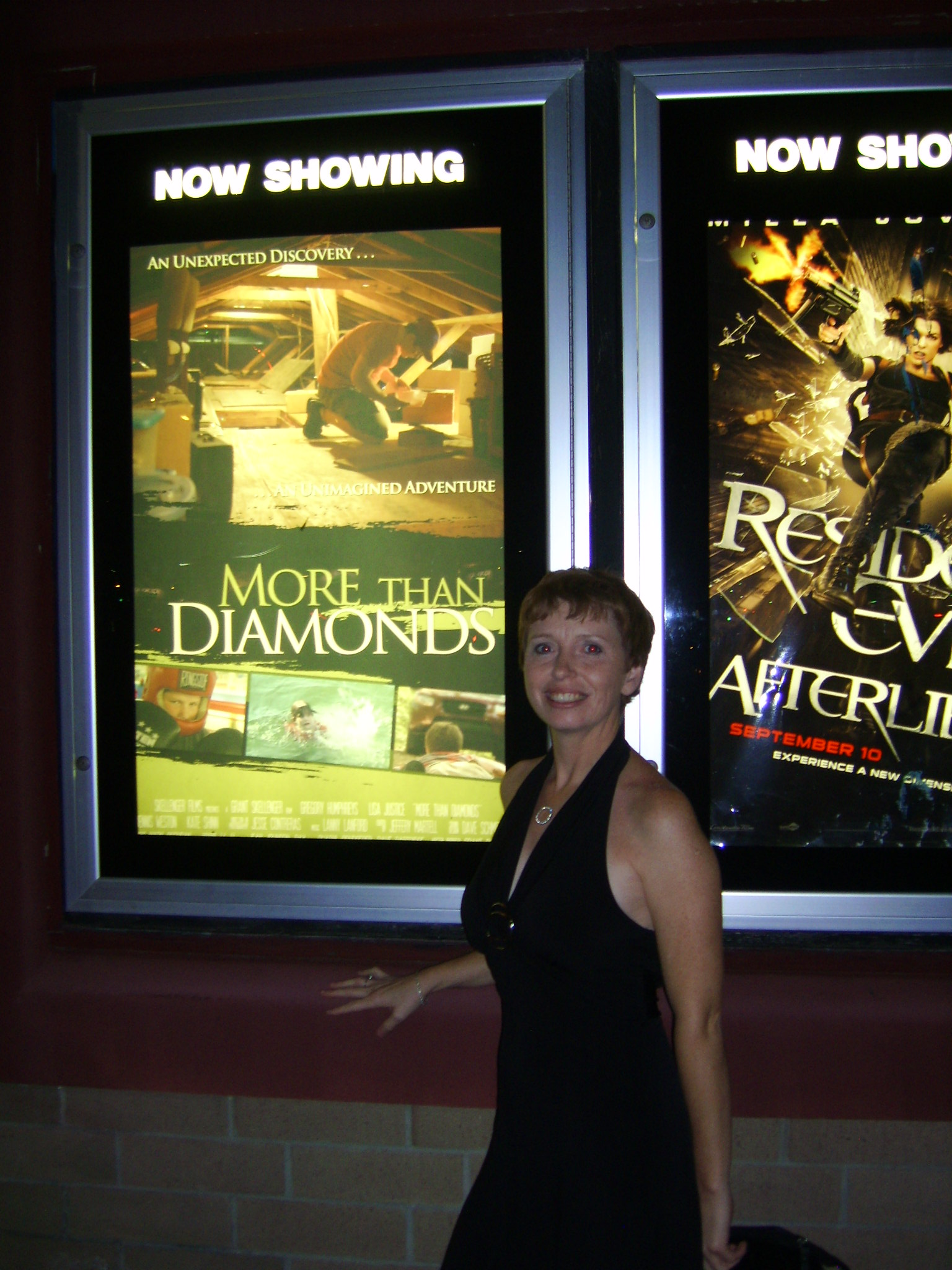 Sonya standing in front of the movie poster of More Than Diamonds