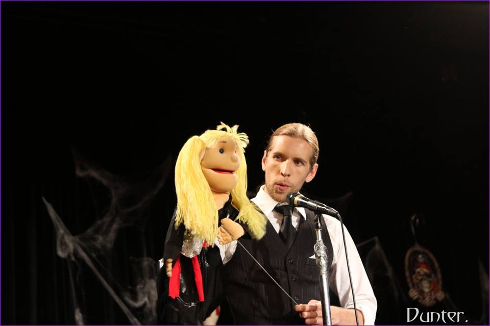 Still of Corey Tomicic and puppet Millie performing at the Candyass Cabaret