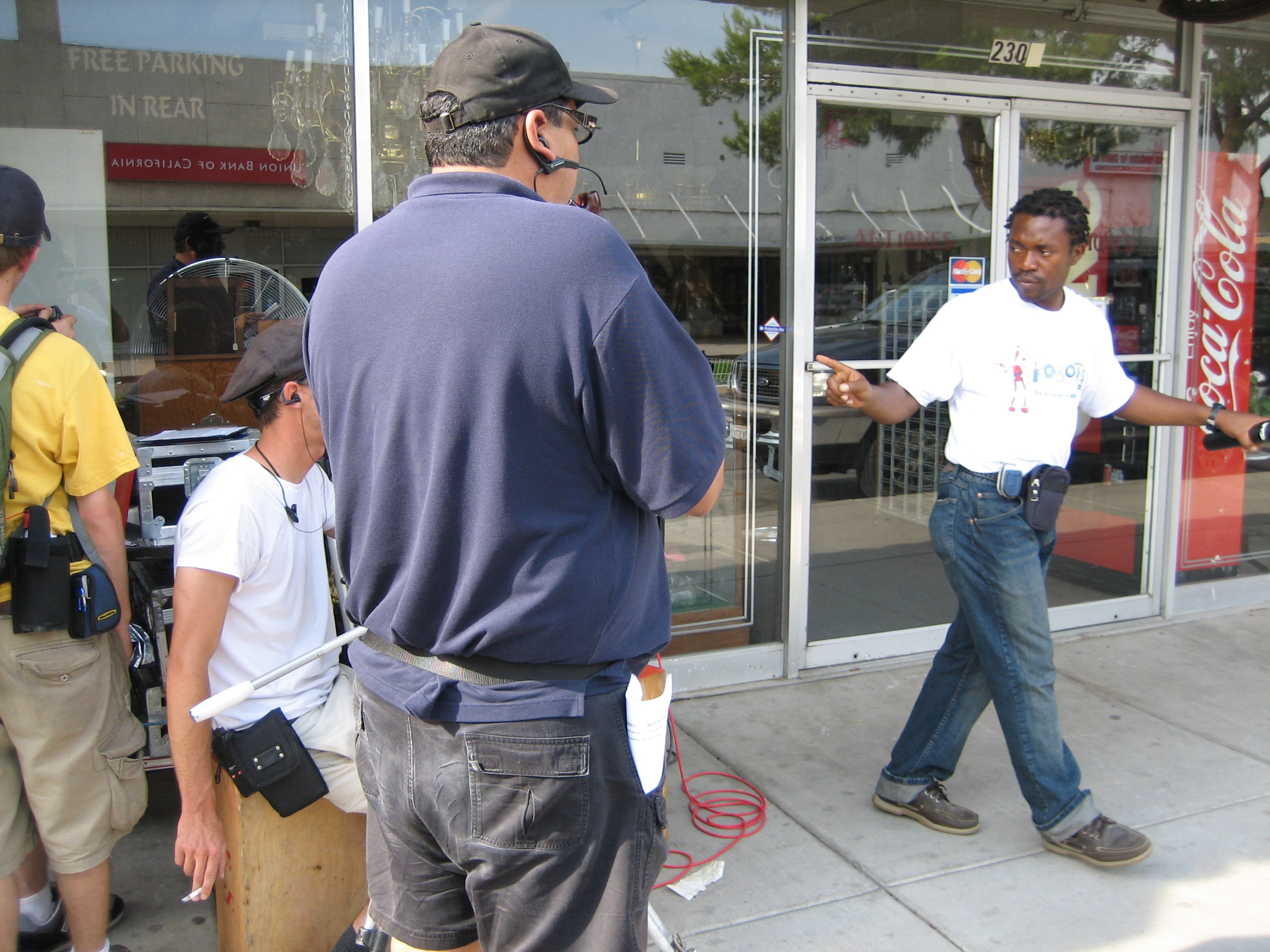 Director of Photography Austin F. Schmidt and Stunt Coordinator Gary Robert look on as Producer/Writer/Director Dee Asaah blocks a scene on a main street in Barstow, California.