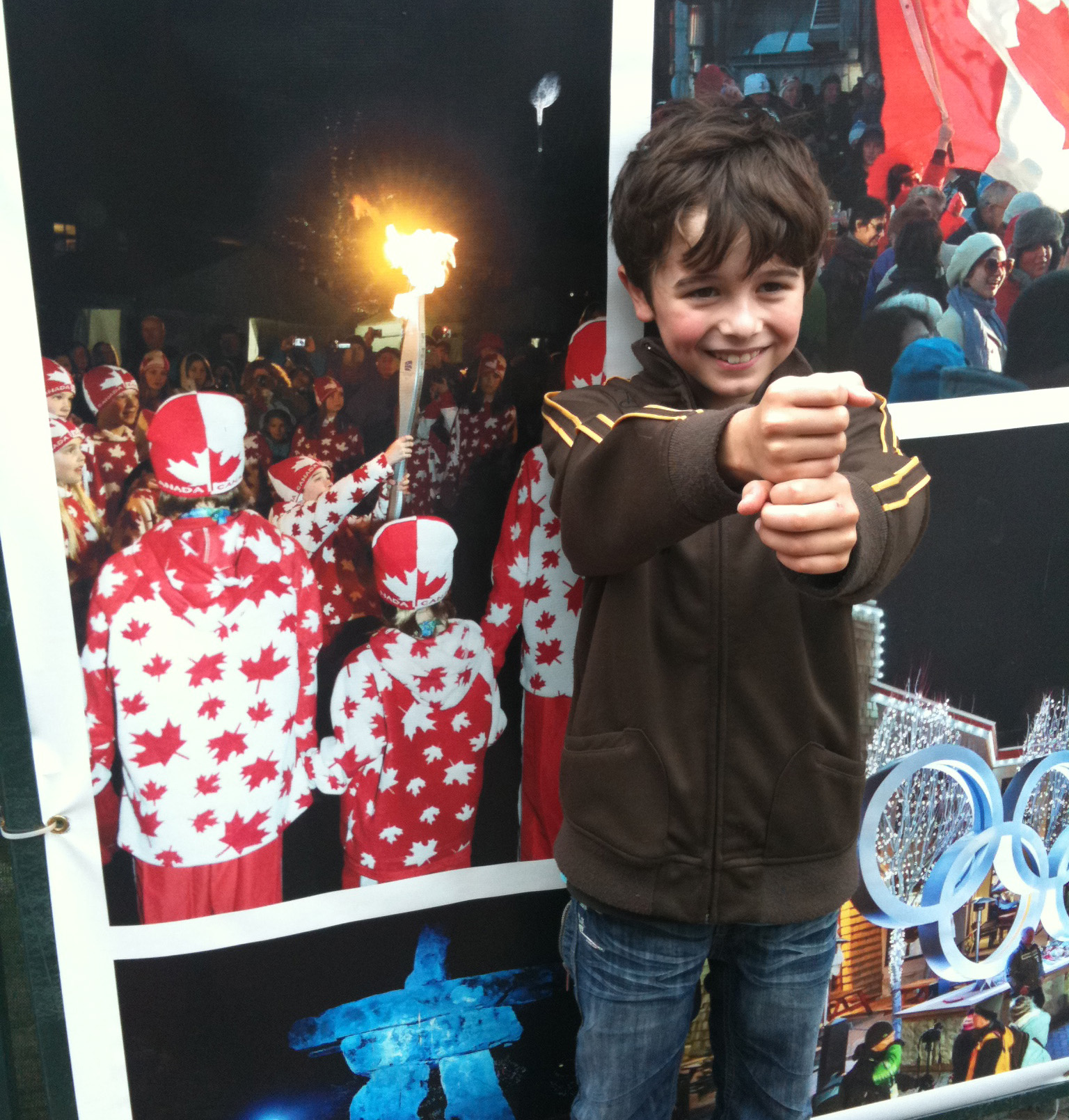 Valin in front of photo of himself carrying the games torch in the Whistler city square.