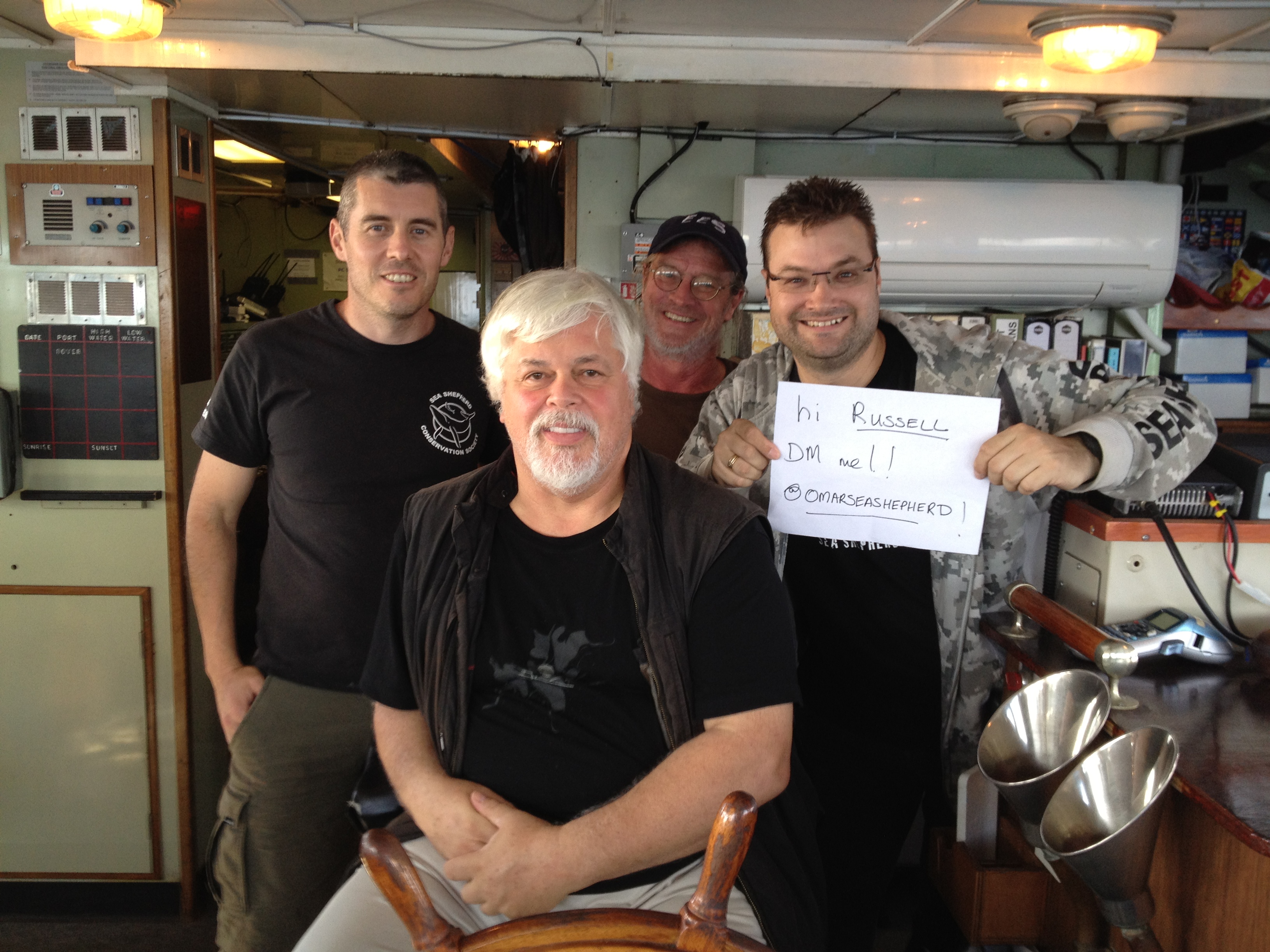On the bridge of the Steve Irwin with Australian Director Jeff Hansen, Captain Paul Watson, Legend Peter Brown and myself holding a sign up to Russell Crowe to prove who we are.