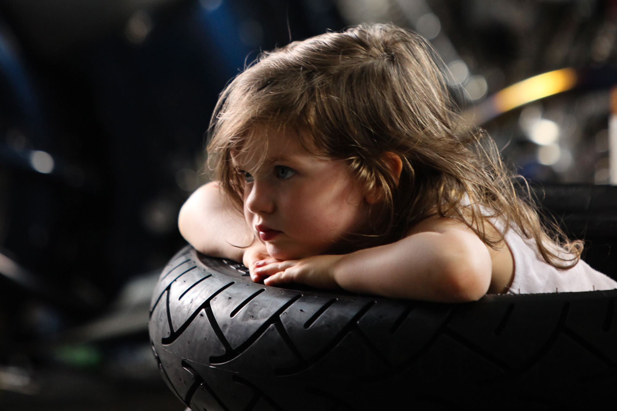 olivia in stack of tires / bike shop scene