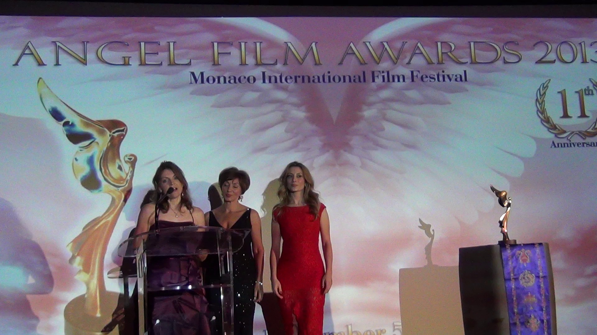 Film Director Jolanda Ellenberger (left) thanks the jury and audience for her BEST HUMANITARIAN SHORT FILM ANGELS AWARD at the Monte Carlo award ceremony on December 7, 2013. Film Producer Daniella Gonella (middle) & Actress Antonella Savucci (right)